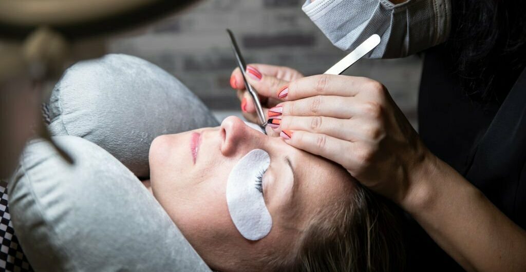 Extensions of artificial eyelash, process close up. Woman in beauty salon. Beauty and self care. eyelash extension application