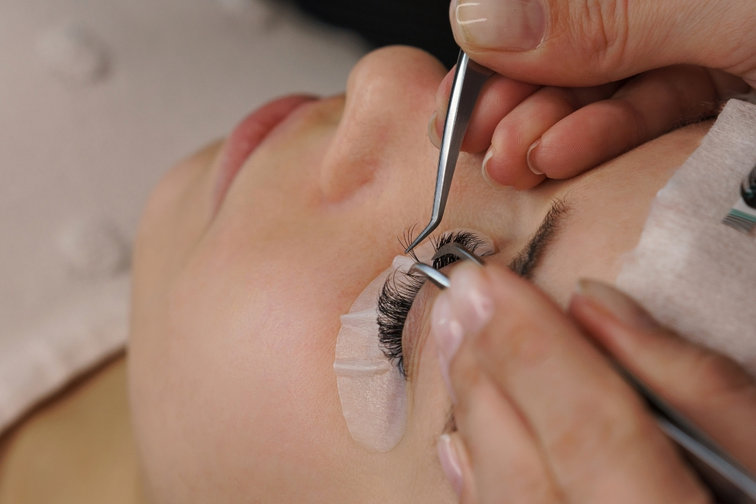 Lash adhesive viscosity explained - for choosing the right lash glue Applying lashes using a low viscosity adhesive in a humid lash studio.